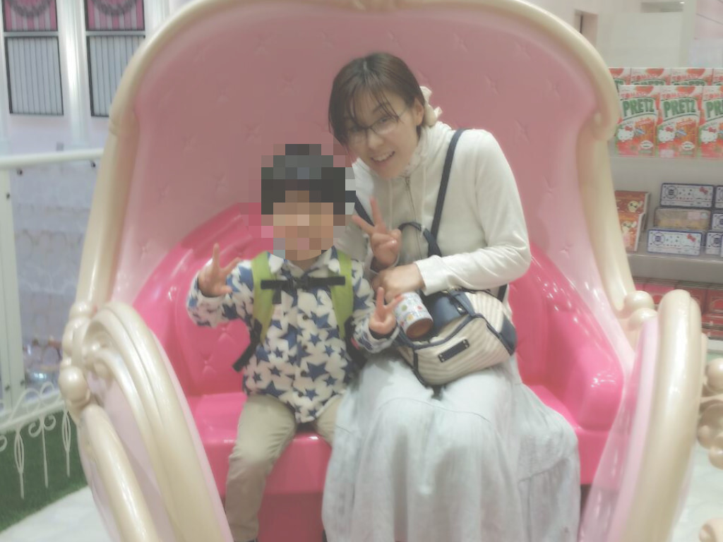 大きなピンク色の椅子に並ぶ、よしみさんと幼い頃の息子さん